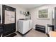 Bright laundry room equipped with modern washer and dryer, shelving, storage, and access to the outside at 2374 Buchanan Hwy, Dallas, GA 30157