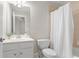 Well-lit bathroom featuring a white vanity, toilet, and a shower-tub combination with a white shower curtain at 4126 Gold Mill Rdg, Canton, GA 30114