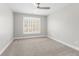 Bright bedroom featuring neutral carpet, ceiling fan, and large window with plantation shutters at 4126 Gold Mill Rdg, Canton, GA 30114