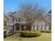 Traditional brick home with a covered front porch and manicured landscaping on a lush green lawn at 4126 Gold Mill Rdg, Canton, GA 30114