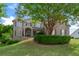 Brick two-story home with mature tree, manicured lawn and garden beds, and a covered front entryway at 4126 Gold Mill Rdg, Canton, GA 30114