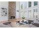 Bright living room featuring a stone fireplace, built-in shelving, and large windows with shutters at 4126 Gold Mill Rdg, Canton, GA 30114