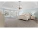 Airy primary bedroom with a tray ceiling, shuttered windows, and chandelier at 4126 Gold Mill Rdg, Canton, GA 30114