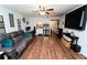 Bright living room with hardwood floors, a ceiling fan, a gray sofa and large TV at 5400 Roswell Rd # K2, Atlanta, GA 30342