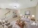 Bright, neutrally decorated living room with a large window, stairs, and cozy seating at 1005 Magnolia Gardens Walk, Mcdonough, GA 30253