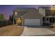 Dusk exterior view showing a two-car garage and backyard at 307 Montgomery Way, Woodstock, GA 30188