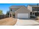 Daytime exterior of a two-story home featuring a driveway, garage, and small backyard space at 307 Montgomery Way, Woodstock, GA 30188