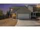 Evening exterior of a two-story home featuring a driveway, garage, and small backyard space at 307 Montgomery Way, Woodstock, GA 30188