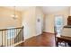 Bright hallway boasts hardwood floors, wrought iron railing, and natural light from the window and glass pane door at 307 Montgomery Way, Woodstock, GA 30188