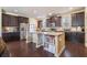 Modern kitchen featuring dark cabinets, stainless steel appliances, and a center island with a built-in bookshelf at 307 Montgomery Way, Woodstock, GA 30188