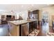 Open kitchen with stainless steel dishwasher and sink in island with barstool seating connected to living room at 307 Montgomery Way, Woodstock, GA 30188