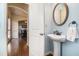 Stylish powder room with pedestal sink, arched doorway, and views into the dining room at 307 Montgomery Way, Woodstock, GA 30188