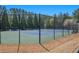 View of community tennis court with green and blue playing surface, surrounded by a black chain link fence at 307 Montgomery Way, Woodstock, GA 30188
