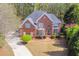 Aerial view of the brick home with a well-manicured lawn and lush surrounding trees at 3816 Berrybridge Se Way, Marietta, GA 30067