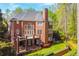 Aerial view of the brick home showing the backyard, deck, and patio with mature trees at 3816 Berrybridge Se Way, Marietta, GA 30067