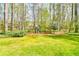 Grassy backyard featuring a swing set, play structure, and wooden pergola at 3816 Berrybridge Se Way, Marietta, GA 30067