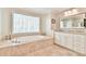 An elegant bathroom with a soaking tub, granite countertops, and double vanity at 3816 Berrybridge Se Way, Marietta, GA 30067