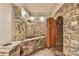 Unique wine cellar room is made of stone with a custom water feature and rustic wooden door at 3816 Berrybridge Se Way, Marietta, GA 30067