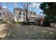 Expansive backyard featuring a well-manicured lawn, mature trees, and a charming brick home with a deck and walkout basement at 12800 Wyngate Trl, Alpharetta, GA 30005
