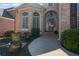 Elegant front entrance with arched windows, a charming door, and meticulously maintained landscaping at 12800 Wyngate Trl, Alpharetta, GA 30005