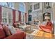 Elegant living room featuring a stone fireplace, hardwood floors, large windows, and custom built-in shelving at 12800 Wyngate Trl, Alpharetta, GA 30005
