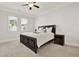 Carpeted bedroom features a dark-wood bed, two windows for natural light, and a bedside table at 2128 Cosette Ln, Kennesaw, GA 30152