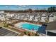 Aerial view of a community pool with a black fence, lounge chairs, and green landscaping with neighborhood in the background at 2128 Cosette Ln, Kennesaw, GA 30152