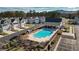 Aerial view of a community pool surrounded by houses and landscaping with a clubhouse and parking spots nearby at 2128 Cosette Ln, Kennesaw, GA 30152