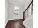 Cozy foyer features hardwood floors, staircase with decorative iron railing, and ample natural light at 2128 Cosette Ln, Kennesaw, GA 30152