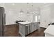 Bright kitchen features a gray island, stainless steel appliances, and an adjacent dining area with modern chandelier at 2128 Cosette Ln, Kennesaw, GA 30152