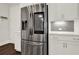 Stainless steel refrigerator with a water dispenser, white cabinets, and a gray tiled backsplash in the kitchen at 2128 Cosette Ln, Kennesaw, GA 30152