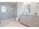 Modern bathroom with glass-enclosed shower, marble tile, grey vanity, and gold fixtures at 835 Kenry Ct, Atlanta, GA 30342