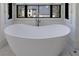 Luxurious bathroom features a modern soaking tub with a large window overlooking the property at 835 Kenry Ct, Atlanta, GA 30342