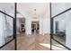 Sunlit foyer with herringbone wood floors, glass front doors, and designer chandelier at 835 Kenry Ct, Atlanta, GA 30342