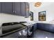 Well-appointed laundry room with modern appliances, custom cabinetry, and stylish herringbone flooring at 835 Kenry Ct, Atlanta, GA 30342