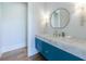 Elegant powder room with a blue vanity, marble countertop, and decorative sconces at 835 Kenry Ct, Atlanta, GA 30342
