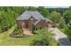 Stately brick home with lush landscaping, mature trees, and a circular driveway at 1391 Harris Rd, Lawrenceville, GA 30043