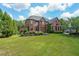 Beautiful home with lush landscaping, green lawn, and mature trees at 1391 Harris Rd, Lawrenceville, GA 30043