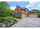 Beautifully landscaped home with a spacious driveway leading to a three-car garage at 1391 Harris Rd, Lawrenceville, GA 30043