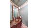 Stylish powder room featuring a unique copper sink, granite countertop, and elegant mirror with decorative lighting at 1391 Harris Rd, Lawrenceville, GA 30043