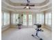 Sitting area with a tray ceiling, ceiling fan, plantation shutters, French doors and an exercise machine at 1391 Harris Rd, Lawrenceville, GA 30043