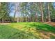 Expansive backyard is surrounded by tall trees and features a lush lawn and dark fencing for privacy at 1718 Barnesdale Ne Way, Atlanta, GA 30309