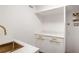 Bright laundry room features white cabinets, gold hardware, quartz countertops and a convenient, modern sink at 1718 Barnesdale Ne Way, Atlanta, GA 30309