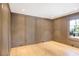 Cozy room featuring wood paneled walls, hardwood floors, and a large window providing natural light at 1718 Barnesdale Ne Way, Atlanta, GA 30309