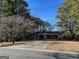 Brick ranch-style home with a two-car carport and mature trees in a serene neighborhood setting at 213 Sharon Drive, Canton, GA 30115