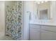 Bright bathroom featuring shower with patterned curtain, and white vanity with mirror and lighting at 4022 Newhaven Ne Cir, Brookhaven, GA 30319