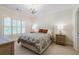 Neutral bedroom with a patterned bedspread, chandelier, and windows with plantation shutters at 4022 Newhaven Ne Cir, Brookhaven, GA 30319