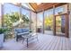 Sunroom with vaulted ceiling, wood floors, gray wicker furniture, glass railings, and backyard views at 4022 Newhaven Ne Cir, Brookhaven, GA 30319