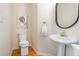 Charming powder room featuring hardwood floors, a pedestal sink, decorative mirror, and a modern toilet at 1926 Regency Cove Ct, Atlanta, GA 30341