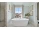 Elegant bathroom featuring a soaking tub with a view and a glass-enclosed shower at 204 N Esplanade, Alpharetta, GA 30009